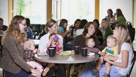 Group Of Young Mothers Relaxing In Cafe