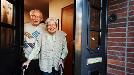 elderly couple opening the front door Image-46194
