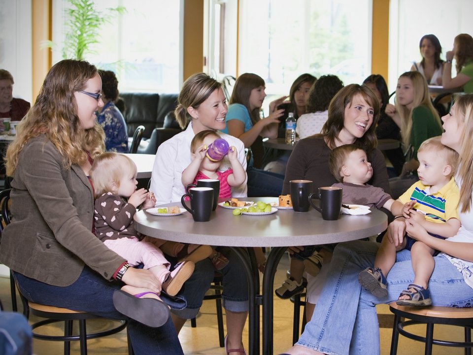 Group Of Young Mothers Relaxing In Cafe